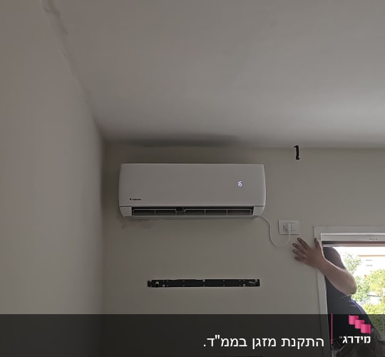 התקנת מזגן עילי לבן של טורנדו על קיר בחדר